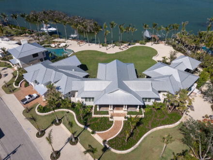 aerial image of large home on the bay with expansive metal roof