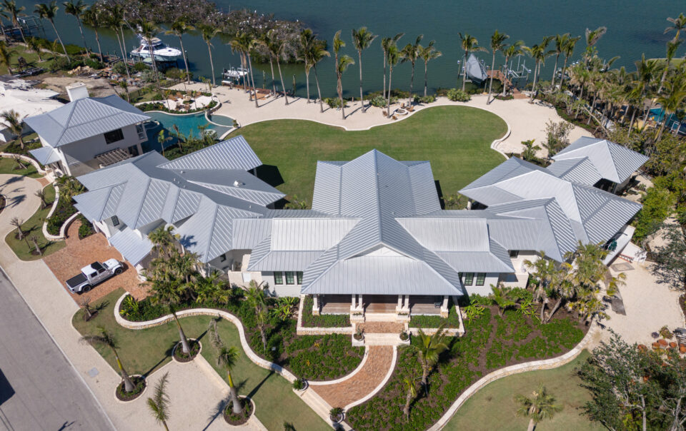 aerial image of large home on the bay with expansive metal roof