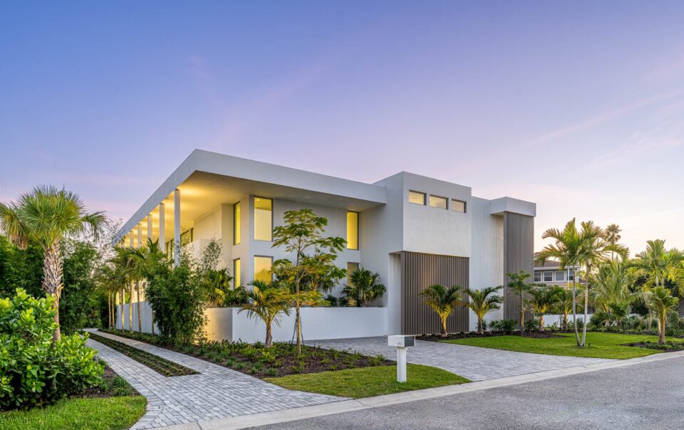 modern white geometrical residence on longboat key florida at sunset with tropical landscaping and bronze sunshades